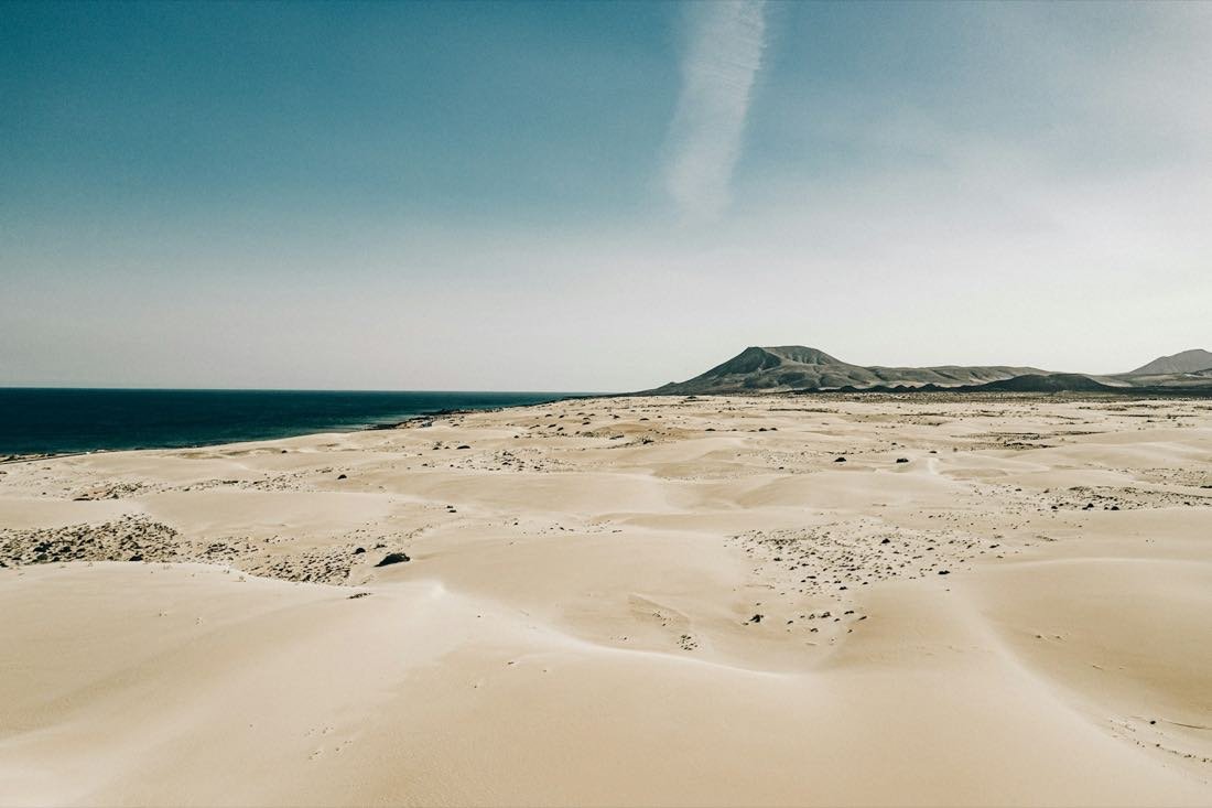 Sandstrand mit Bergkette in der Ferne — Fuerteventura · Spanien