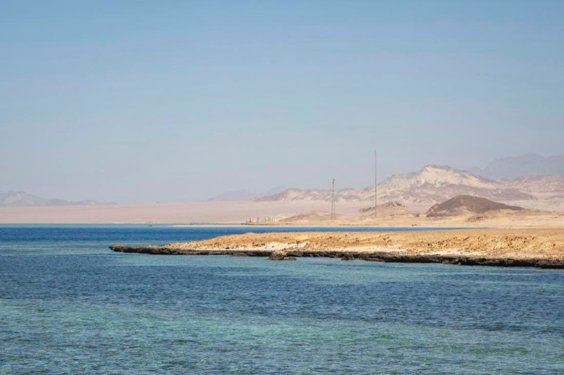 Klares Wasser trifft Sandküste, Berge in der Ferne — Rotes Meer · Ägypten